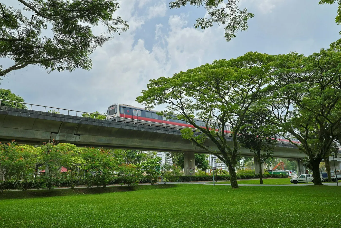 MRT train crossing a bridge over a green park in Singapore